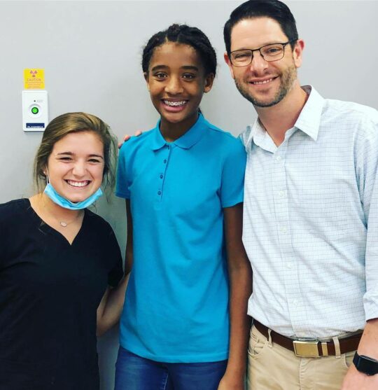 Dr. Burton with a patient and SmileMaker team member